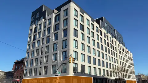 Mid-rise multifamily development with ground-floor retail on urban infill site illustrating highest-and-best-use zoning yield optimization.