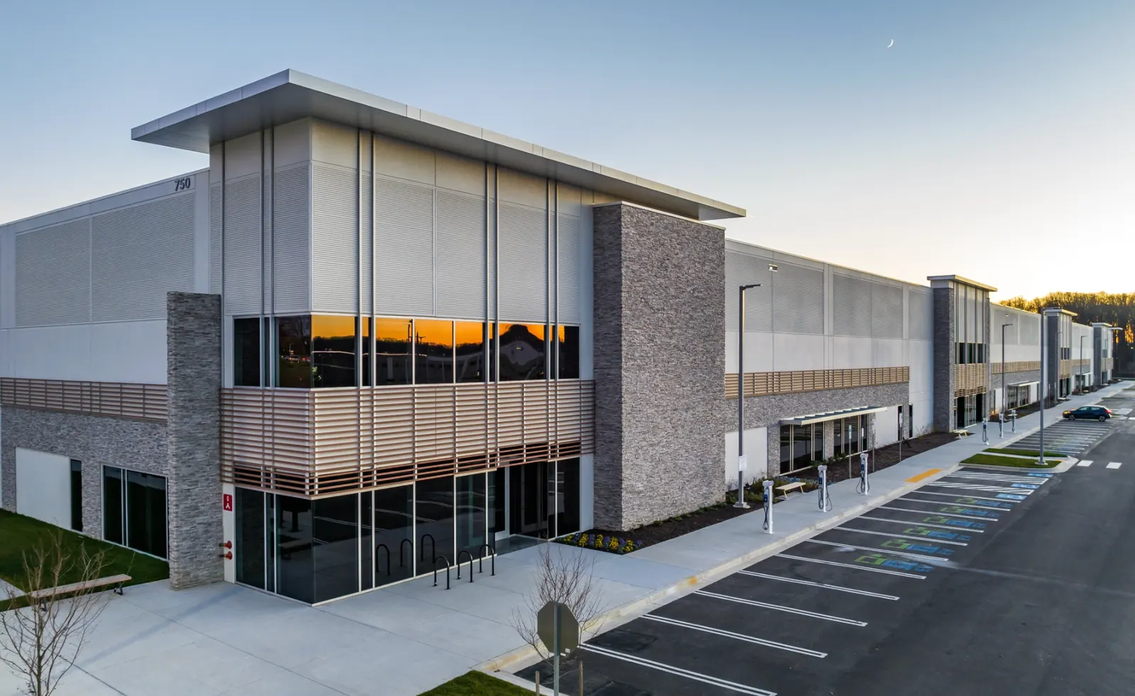 Modern flex-industrial building with surface parking lot, a development typology directly shaped by municipal parking minimums and FAR regulations.