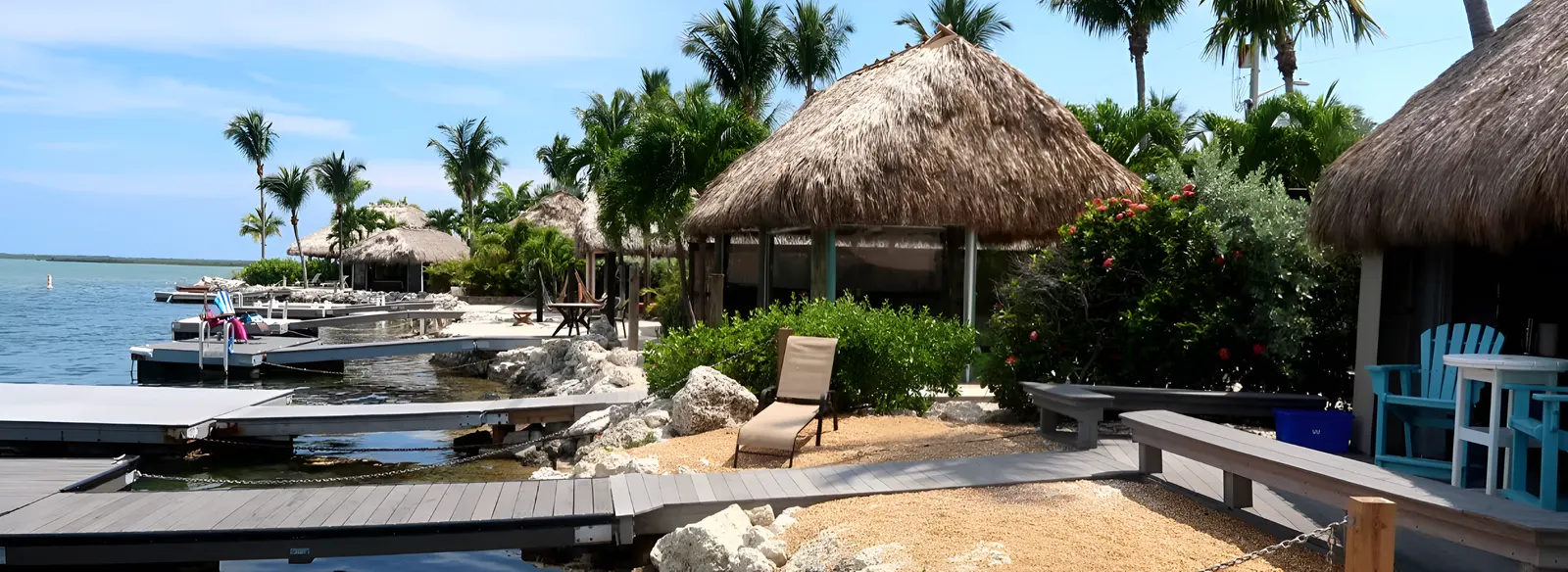 Waterfront RV resort with tiki huts, private docks, and tropical landscaping.