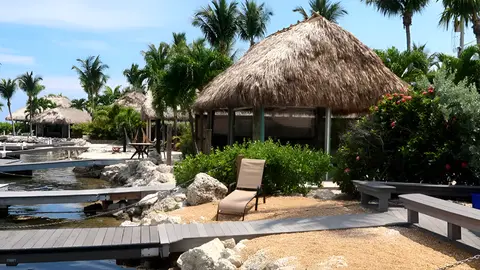 Waterfront RV resort with tiki huts, private docks, and tropical landscaping.