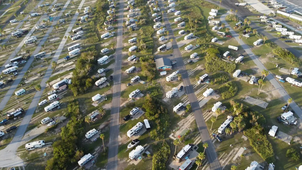 An aerial view of a busy RV park showcasing crowded campsites. Strong seasonal demand often pushes popular RV parks to full capacity, highlighting how occupancy rates have surged while new supply remains limited. The high utilization of existing parks underscores the attractive fundamentals driving RV park investment opportunities.
