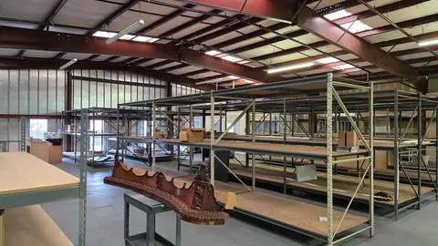 Interior of a small-bay flex industrial building showing open-span steel structure, pallet racking, and mixed-use storage, a typical flex space tenant configuration.