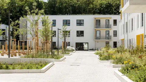 Three-storey senior living building with landscaped courtyard and accessible entry