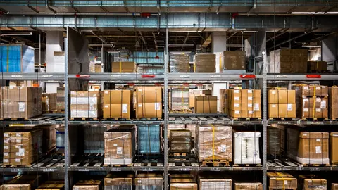A modern warehouse interior with tall racking systems, exemplifying the booming logistics and industrial real estate market driven by e-commerce.