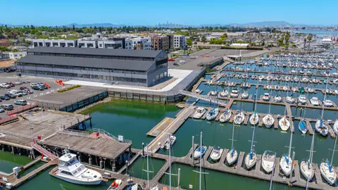 Aerial view of a California Bay Area marina showing wet slip configuration, finger pier layout, and adjacent waterfront commercial development, illustrating the USACE Section 10 and CCC coastal permitting environment for mixed-use marina projects.