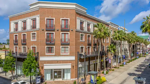 Mixed-use multifamily building with ground-floor retail in a Sun Belt growth market, reflecting typical FAR and site coverage limits under urban zoning.