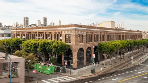 Historic low-rise brick commercial building in San Francisco occupying a full city block, illustrating sub-1.0 FAR development in a high-density urban market where zoning reform and the 2025 Family Zoning Plan are reshaping allowable density limits.