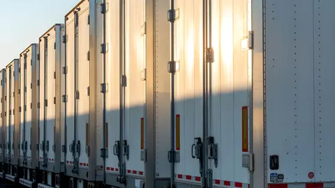 Aerial view of a paved industrial outdoor storage yard with semi-trailers parked.
