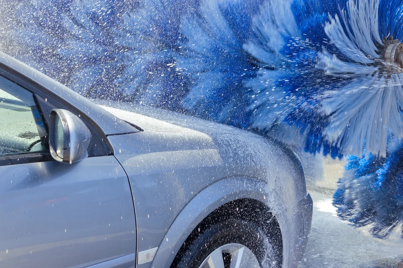 Vehicle passing through an express car wash tunnel conveyor