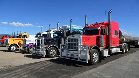 Line of semi trucks parked at a travel center, the format most US truck parking sits in
