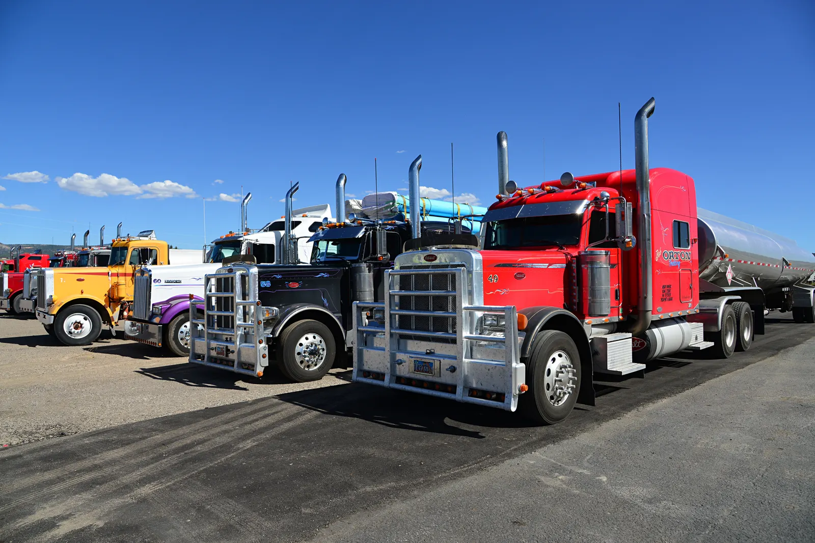 Line of semi trucks parked at a travel center, the format most US truck parking sits in