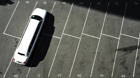 Overhead view of a largely empty numbered surface parking lot
